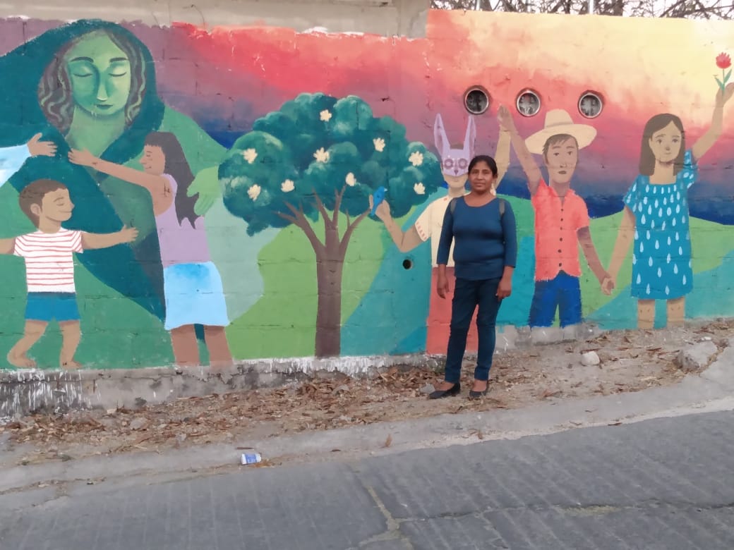 Pie de foto: Virginia Ramírez posa junto a un mural en su pueblo. Crédito: Especial
